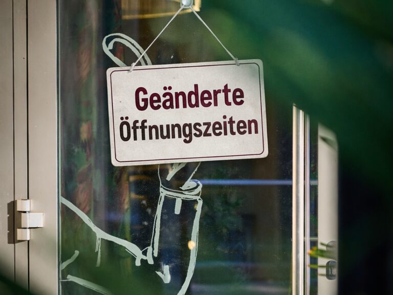 Junge Frau schaut in den Wald während Sie auf dem Fahrrad Pause macht.