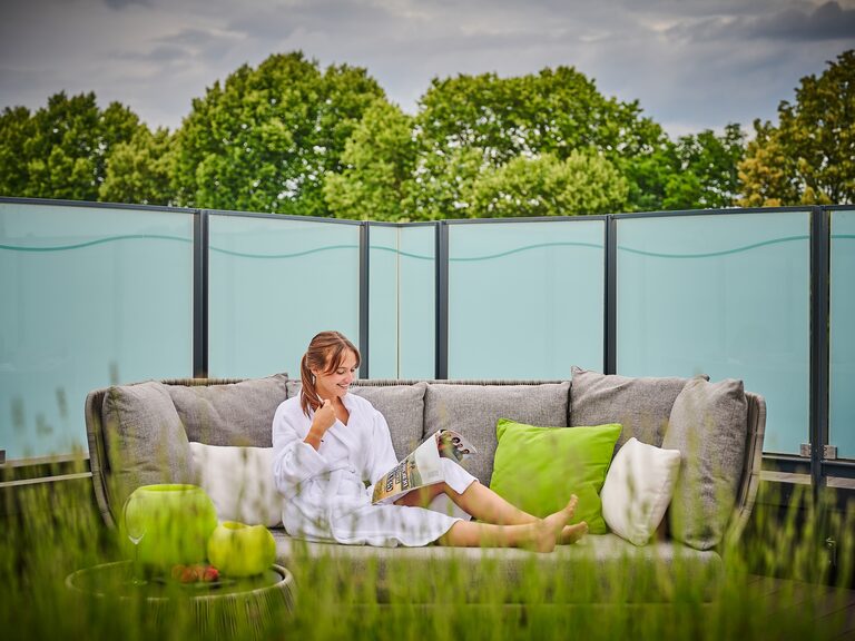 Eine Frau genießt ihren Wellnesstag in einer entspannenden Strandmuschel